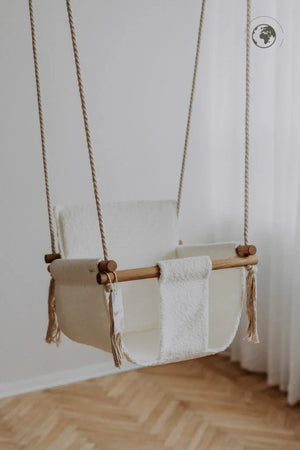 Cream wool baby swing with wooden bar and rope suspension, nursery decor