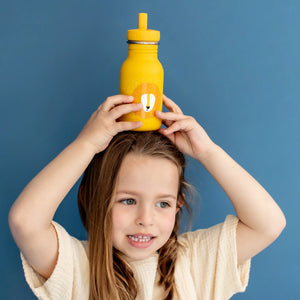 Enfant tenant une gourde en inox jaune avec imprimé lion et couvercle à paille