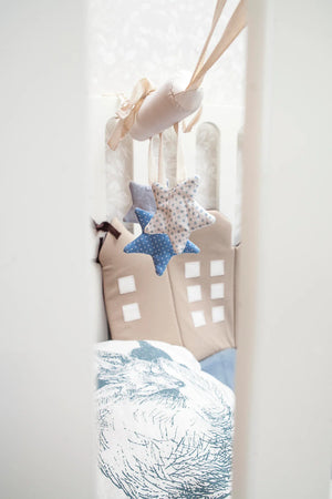 Handcrafted fabric star mobile in blue and beige, hanging above neutral nursery decor