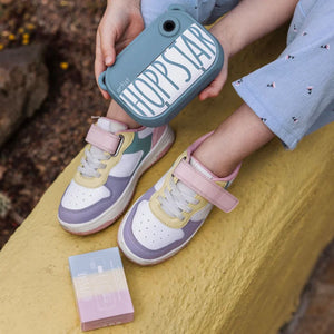 Hoppstar artist kids sneakers with pastel purple, yellow, pink accents and velcro straps, held with matching case