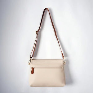 Rückansicht der hellcremefarbenen Älly Cappuccino Handtasche für Babyzubehör mit Außen-Reißverschlusstasche und braunem Umhängegurt.