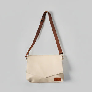 Hellcremefarbene Älly Cappuccino Kompakt-Handtasche für Babyzubehör mit braunem Umhängegurt.