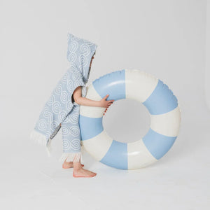Blue bamboo kids bath poncho with hood and white pattern, worn by child next to pool float