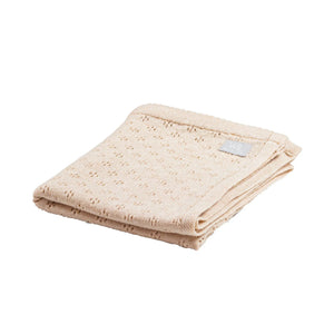 Couverture bébé en tricot beige en coton bio avec subtil motif à pois, pliée