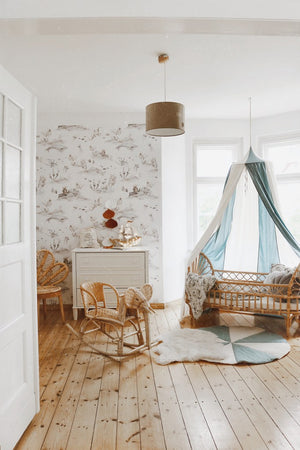 Wide ocean-themed nursery with the Blue Circus canopy above a rattan bed and wooden rocking horse