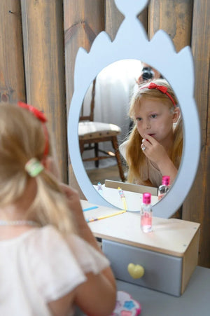 Child looking into gray Crown dressing-table mirror during pretend beauty play
