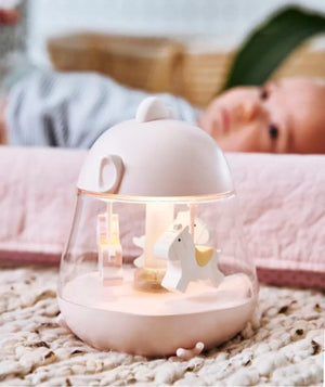 Luce notturna per nursery rosa e bianca con figurine di cavalli a giostra su tappeto dalla trama morbida