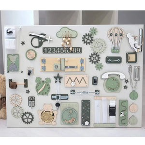 Wooden sensory activity board with green, beige, and white elements including gears, zippers, clock, and numbers for toddler development