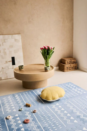 Tapis de jeu puzzle en mousse boho azur avec motif géométrique dans une chambre d'enfant minimaliste