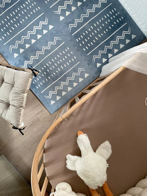 Tapis de jeu puzzle en mousse boho azur avec motifs géométriques blancs dans une chambre d'enfant moderne