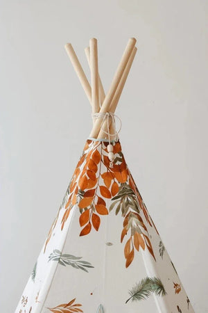 Close-up of natural pine teepee poles and orange woodland leaves on the Forest Friends fabric