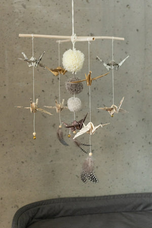 Full view of the Moi Mili Gold Dust mobile with paper birds, pompoms and feathers