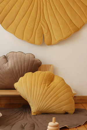 Close lifestyle view of Honey Ginkgo Leaf Mat with coordinating golden and taupe shell cushions