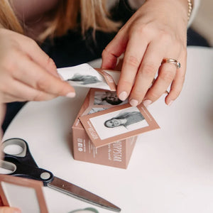 Jeu de mémoire avec cartes illustrées et boîte beige, mains arrangeant les pièces, ciseaux à proximité
