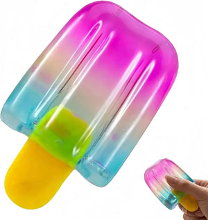 Rainbow gradient popsicle-shaped squishy stress relief toy in pink, blue, and yellow.
