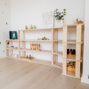 Natural wood One Little Pine modular shelving arrangement styled with books, wooden toys and learning materials