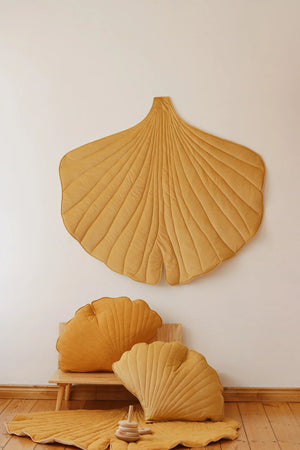 Warm neutral children’s room styled with Honey Ginkgo Leaf Mat wall décor and soft quilted cushions