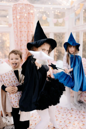 Children wearing black and blue Moi Mili magic capes and witch hats during imaginative group play