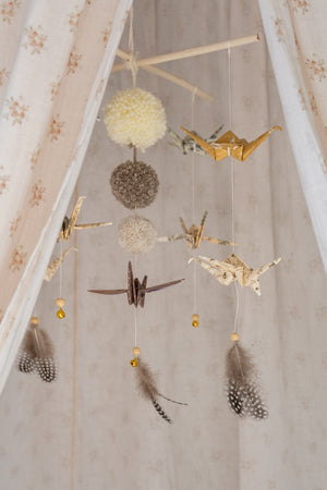 Gold and patterned origami cranes with grey feathers and tiny bells