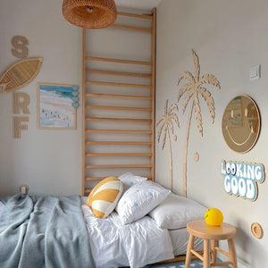 Escalera de pared de madera con calcomanías de palmeras, arte de surf y decoración costera infantil.