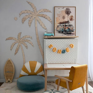 Arte mural de palmera de madera con tabla de surf, silla de terciopelo amarillo y ambiente infantil estilo costero.