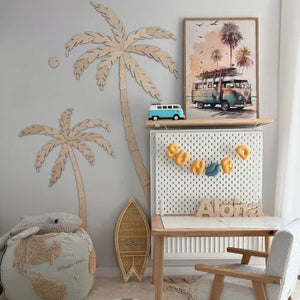 Decoración de pared de palmera de madera con tabla de surf, letrero 'Aloha' y arte de furgoneta vintage en la habitación infantil.