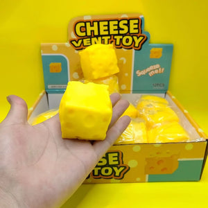 Ръка държи жълта антистрес играчка „Сиренце“ (Cheese Vent Toy), извадена от дисплей кутия с меки играчки.