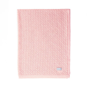 Couverture bébé en tricot rose avec motif losanges, coton doux, pliée sur fond blanc