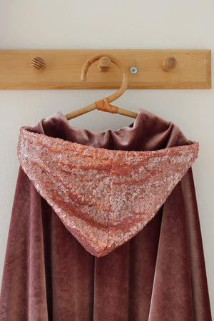 Back detail of pink Moi Mili cape showing the sparkling sequin-covered hood
