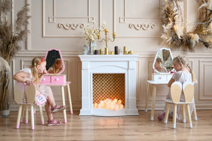 Two children using pink and white Tulip dressing tables in an elegant playroom