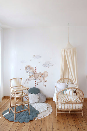 Raw cotton canopy styled in a carousel-themed rattan nursery with shell-shaped floor mats