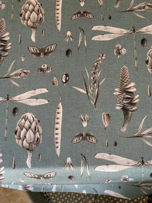 Sage green fabric with vintage botanical print featuring pinecones, dragonflies, and moths for home decor