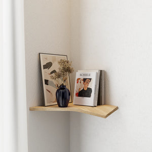 Mensola ad angolo da parete in legno curvato con vaso blu, fiori secchi, stampa d'arte e libri