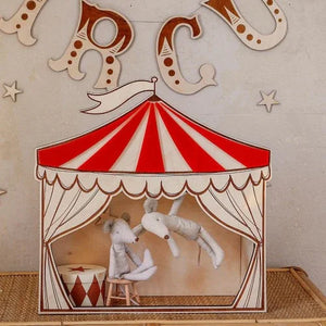 Red and white striped circus tent nursery decor with plush mice performers, wooden accents, and star wall art