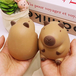 Two brown capybara squishy stress relief toys held in hands