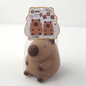 Brown capybara squishy toy in a white mesh bag with a decorative cardboard tag