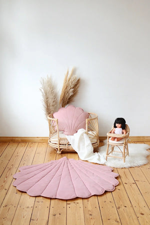 Powder pink shell playmat styled with a rattan basket, doll chair and matching shell cushion