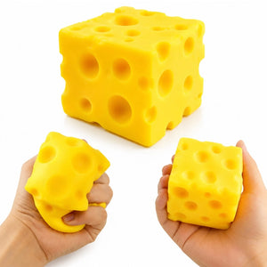 Yellow cube-shaped sqishy cheese with holes, one held in a hand on a white background