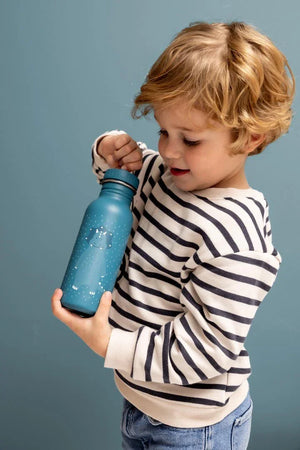 Enfant tenant une gourde en inox bleue illustrée d’un tricératops