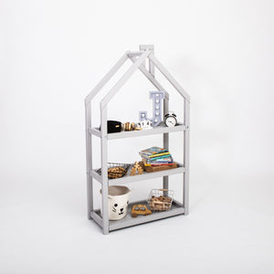 Scaffale grigio a forma di casetta per bambini con libri, cesti, giocattoli in legno e un orologio su sfondo neutro da studio