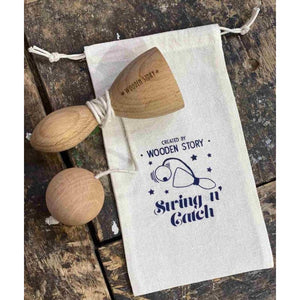 Wooden Story Swing and Catch game displayed on branded cotton storage pouch