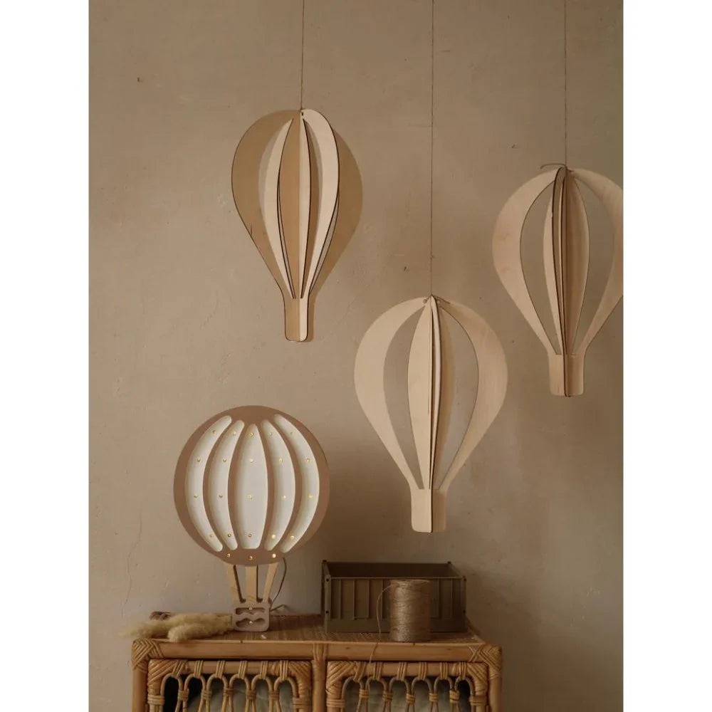 Wooden hot air balloon nursery decor with warm LED lights, natural finish, hanging above rattan console