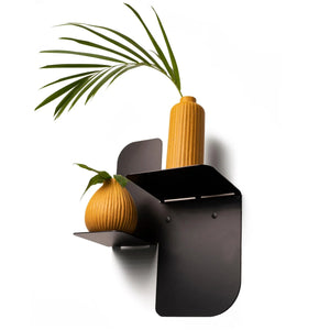 Moderna mensola da parete in metallo nero con due vasi in ceramica color senape opaco e foglie verdi