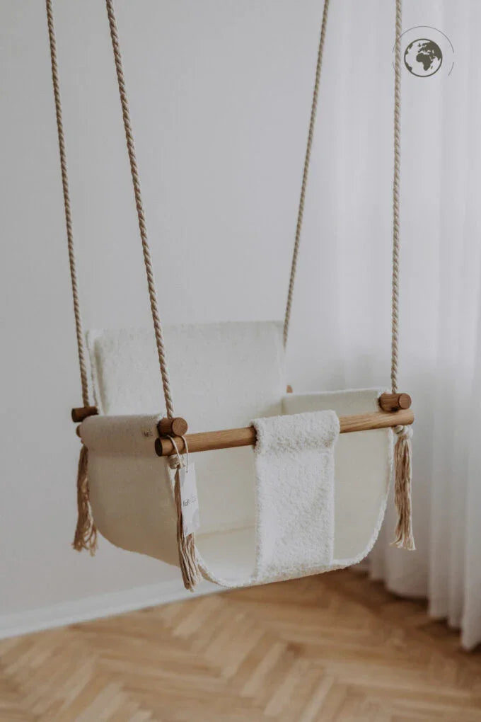 Cream wool baby swing with wooden bar and rope suspension, nursery decor