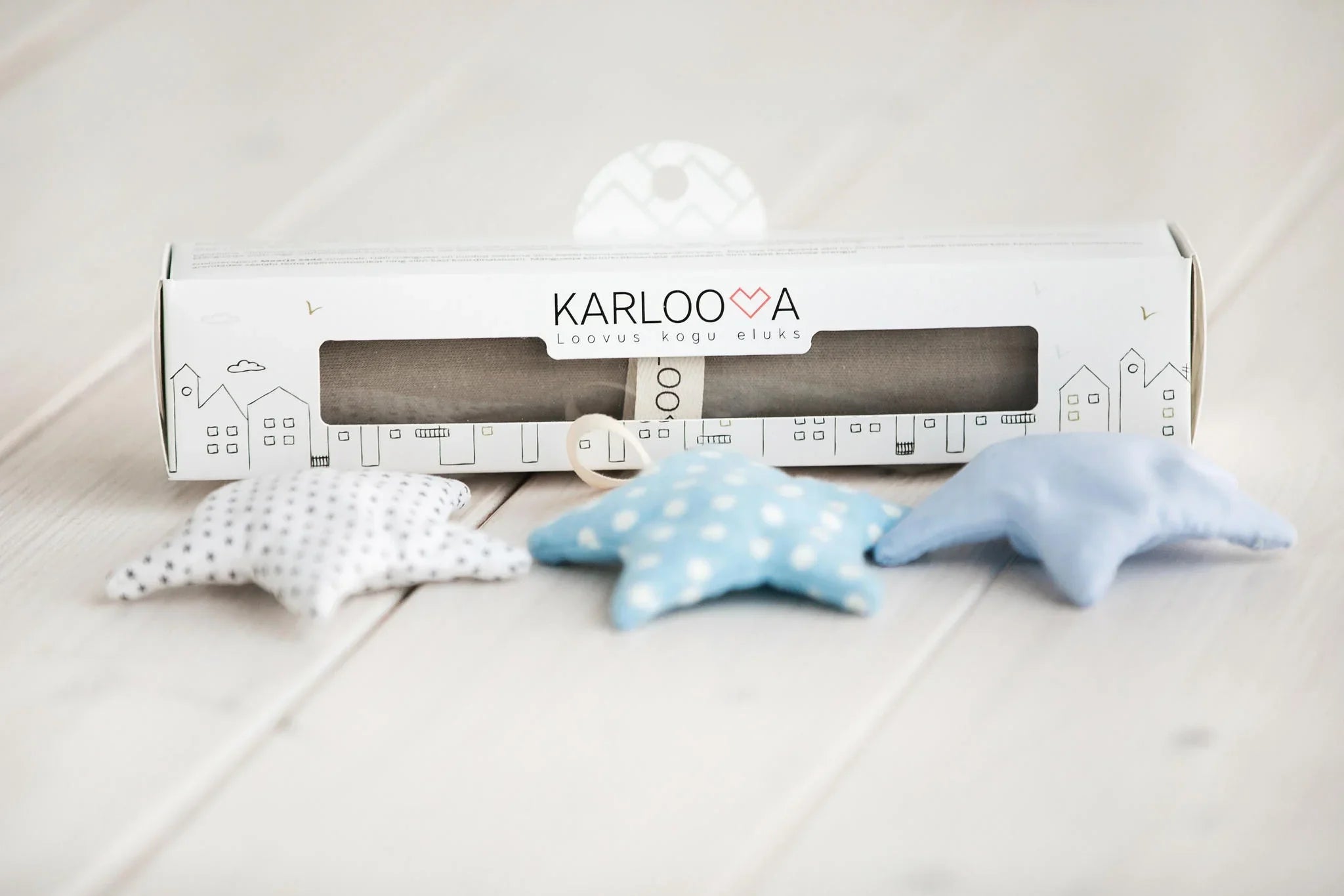 Soft fabric star nursery decor set in pastel blue and white patterns on wooden floor