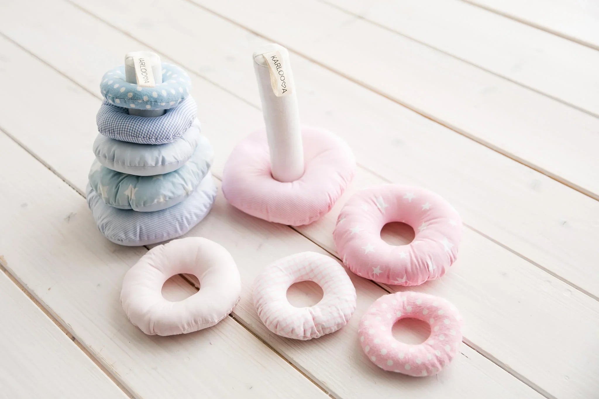 Soft fabric baby stacking rings toy in pastel pink and blue with polka dot and star patterns