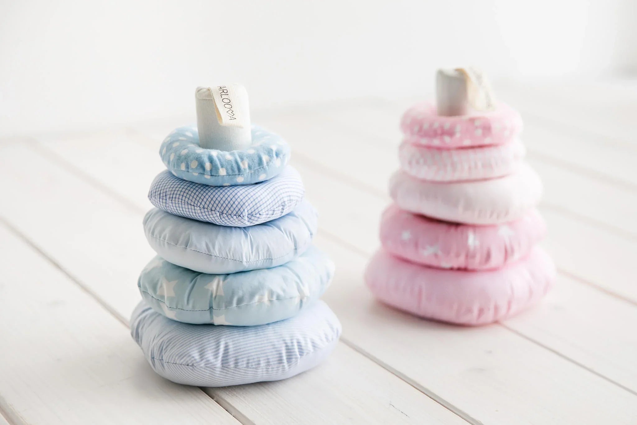 Soft fabric stacking toy with blue and pink pastel rings, baby nursery decor