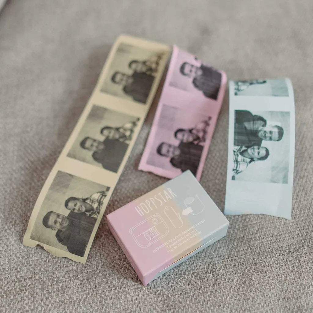 Hoppstar instant photo paper rolls in beige, pink, and white with printed family photos on textured fabric