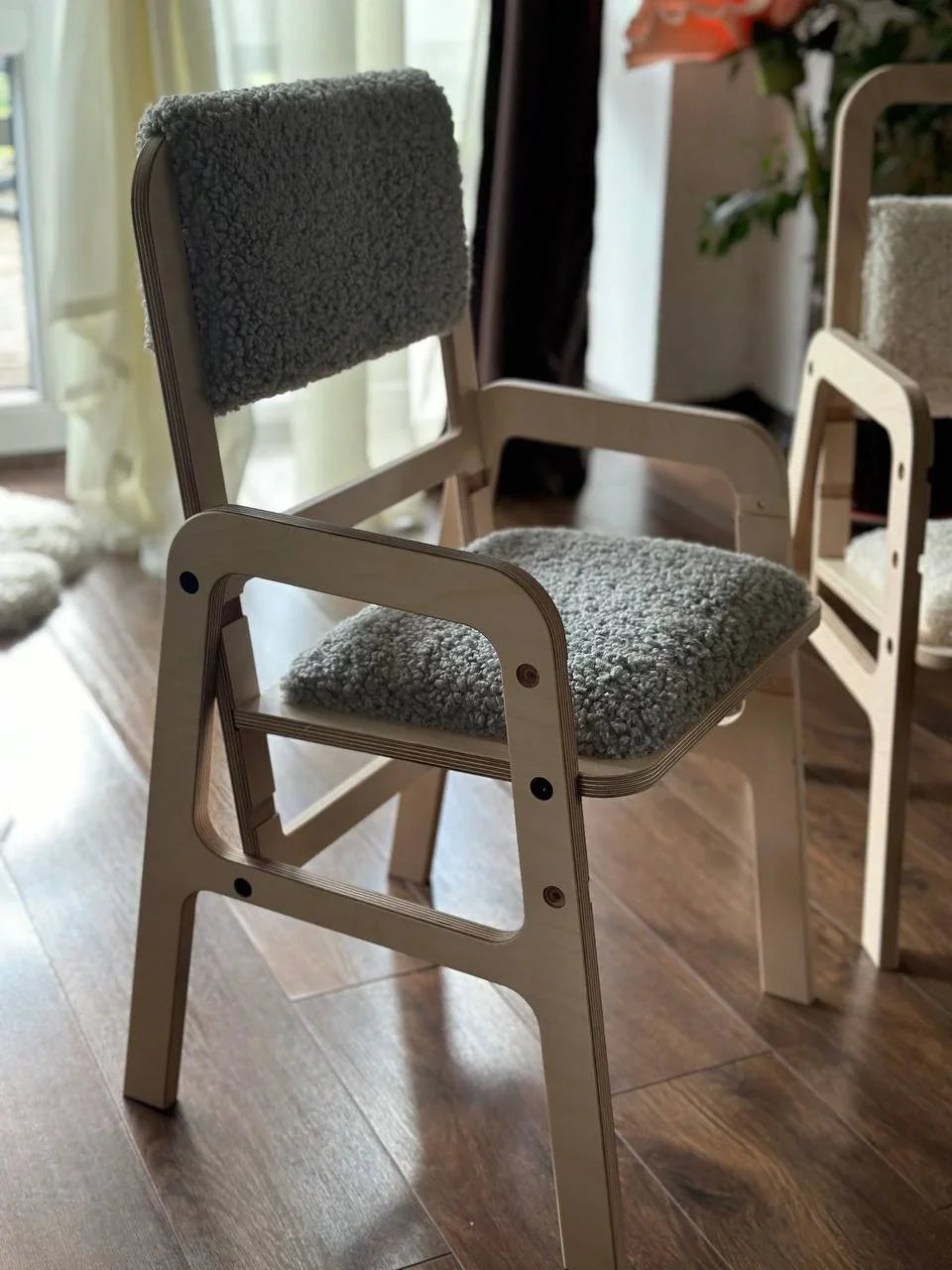 Light wood armchair with gray bouclé cushion, modern nursery furniture
