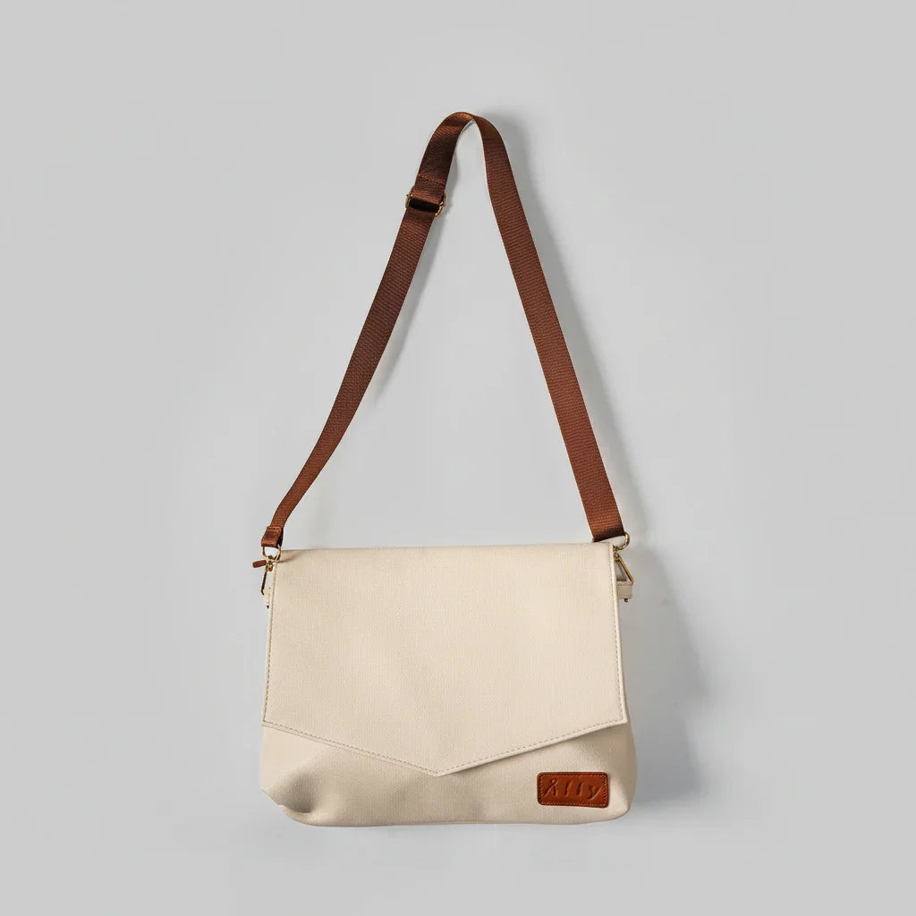 Hellcremefarbene Älly Cappuccino Kompakt-Handtasche für Babyzubehör mit braunem Umhängegurt.